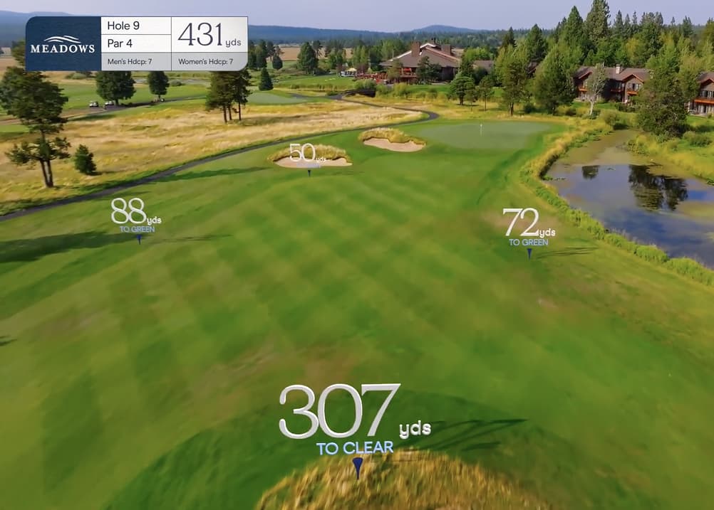 Aerial approach view of Meadows Golf Course Hole 9, a 431-yard par 4 featuring a wide fairway, greenside bunkers, and a water hazard along the right near the clubhouse.