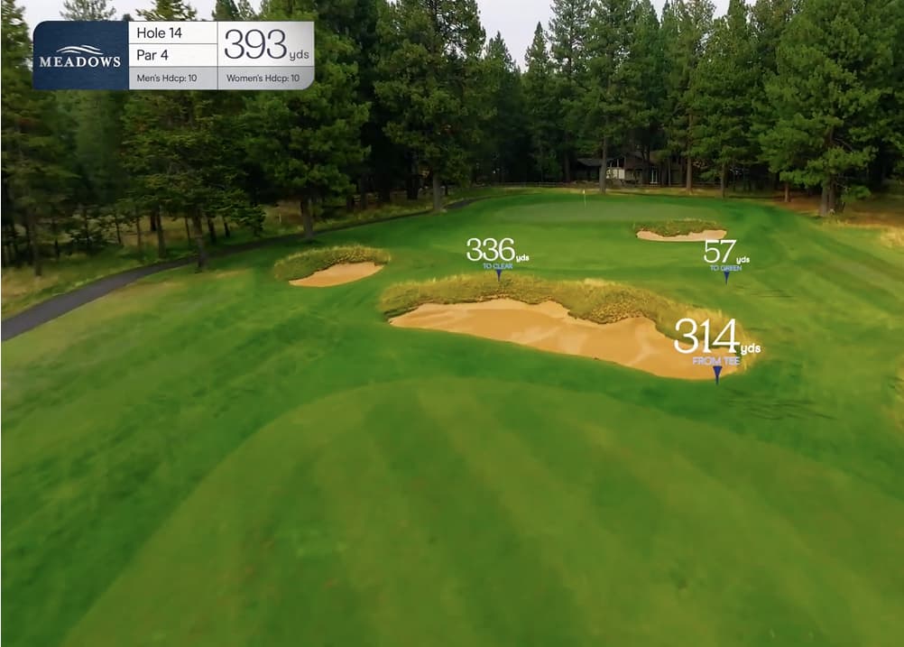 Aerial approach view of Meadows Golf Course Hole 14, a 393-yard par 4 featuring a tree-lined fairway and multiple large bunkers guarding the green.