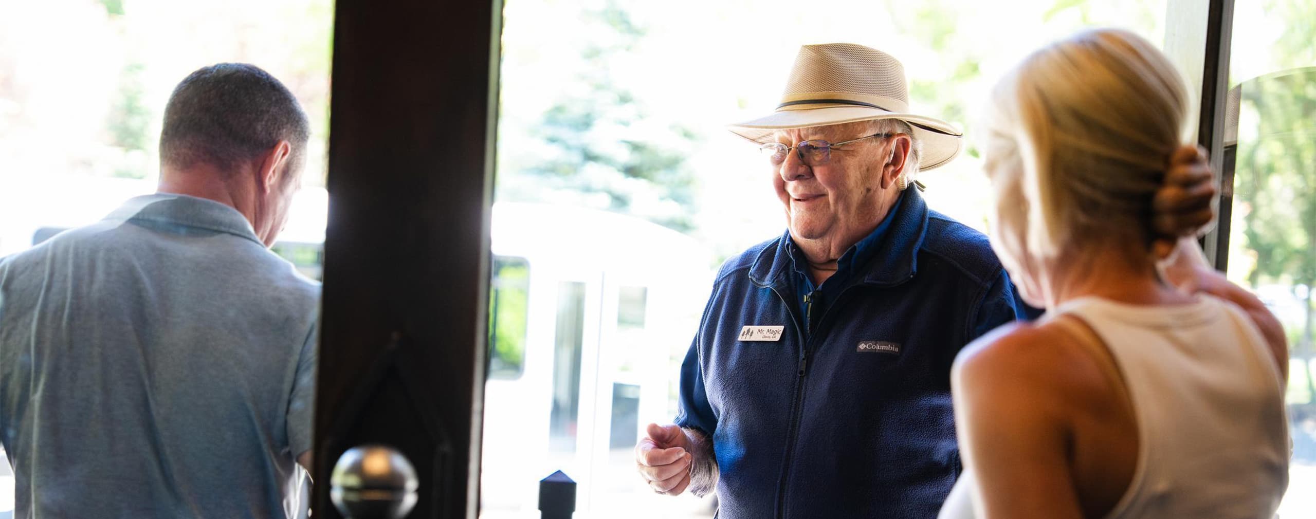 bell service employee speaking with guests and greeting them at the lodge doors