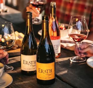 Erath wine on a table with people drinking outside
