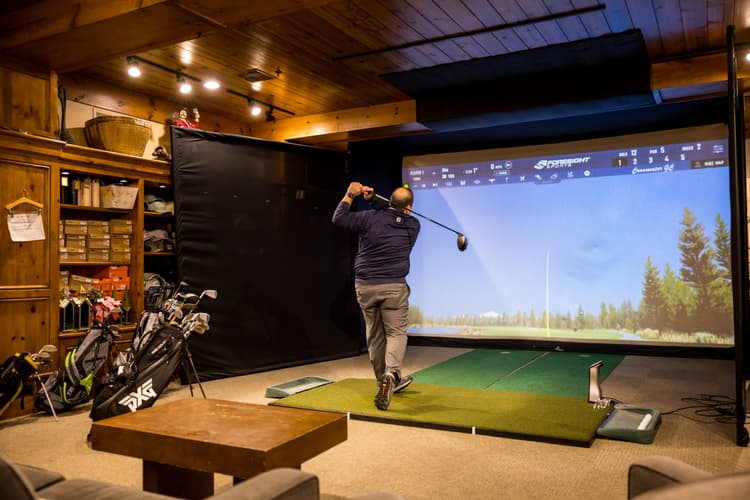 virtual golf, man swinging golf club, playing golf simulator