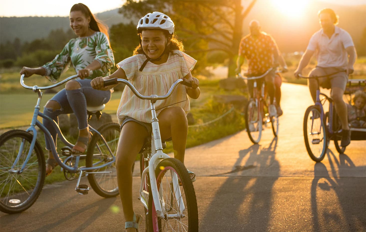 family riding bikes in sunriver at sunset
