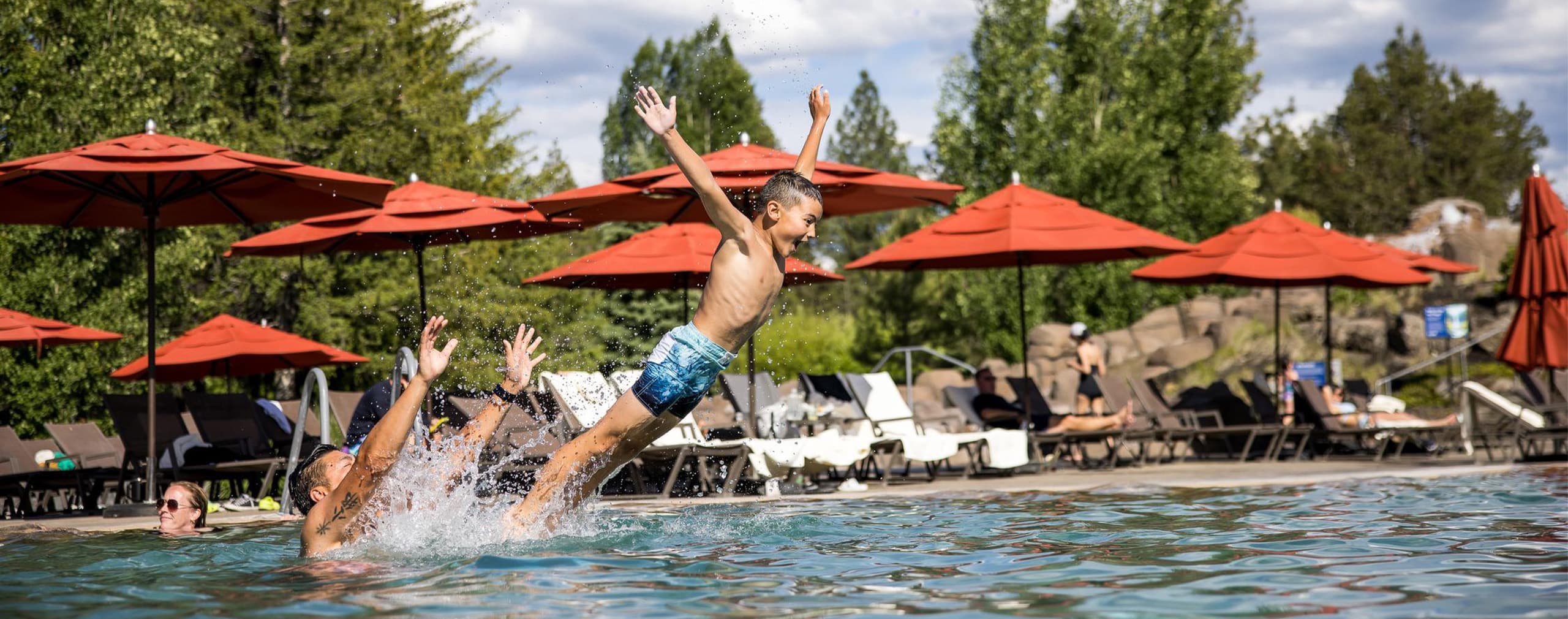 kid jumping in an outdoor pool at the cove